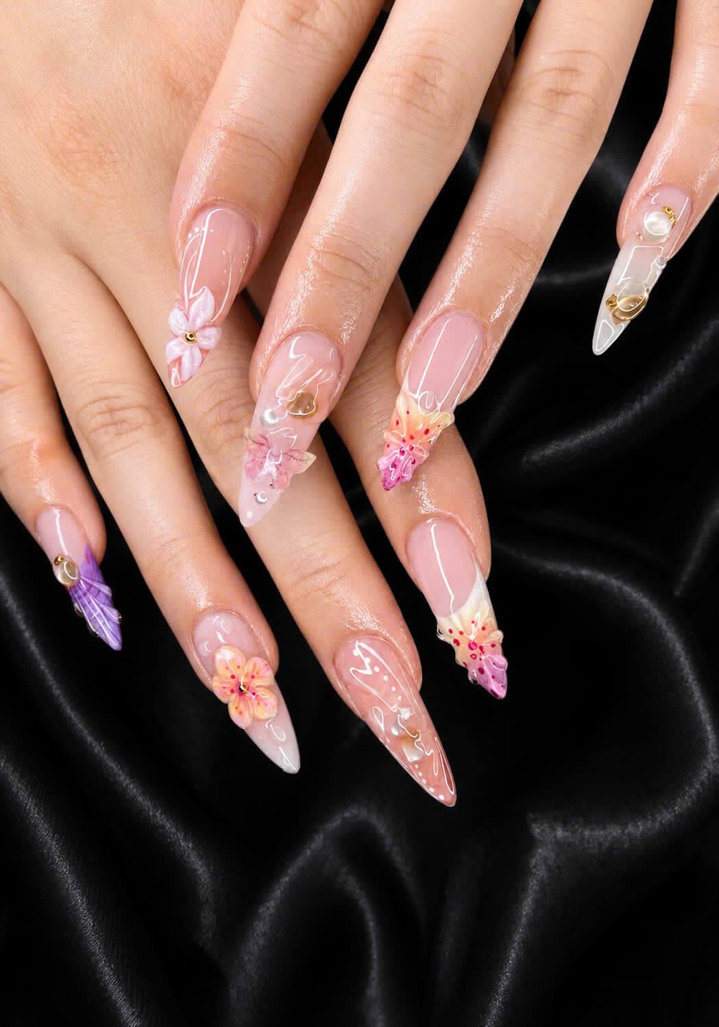 Pink floral nail art on a black satin background
