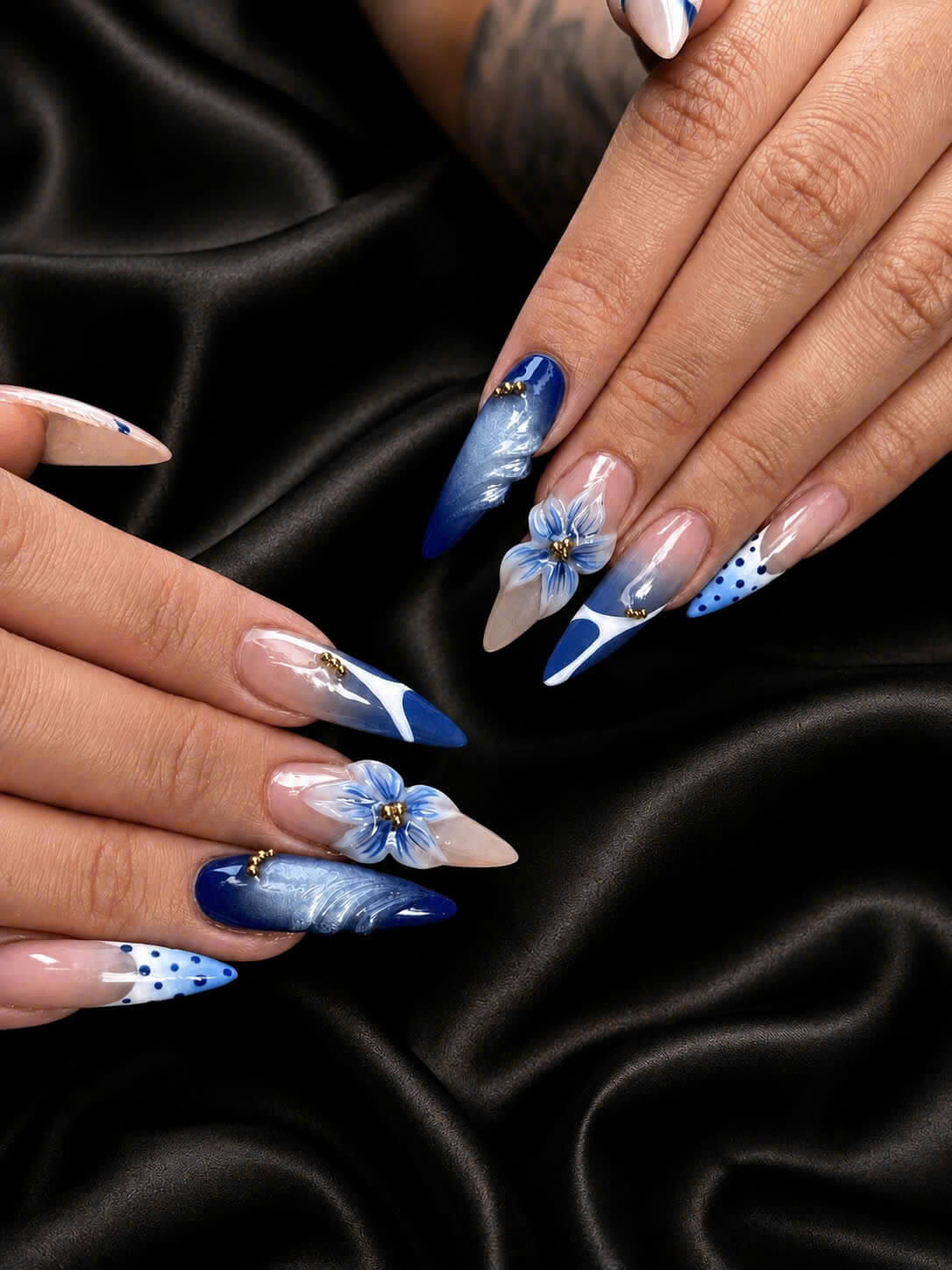 Blue floral nail art on a black satin background