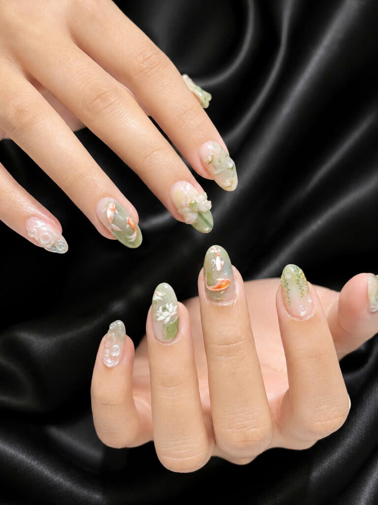 Sage green floral manicure with translucent petals on black silk