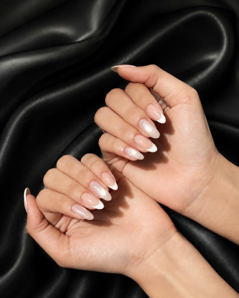 Soft nude French manicure with a pearly shimmer on black silk